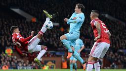 Pemain Manchester United, Jesse Lingard (kiri) berusaha melakukan tendangan salto ke gawang PSV Eindhoven dalam laga Grup B Liga Champions di Stadion Old Trafford, Manchester, (25/11/2015). (AFP Photo/Oli Scarff)