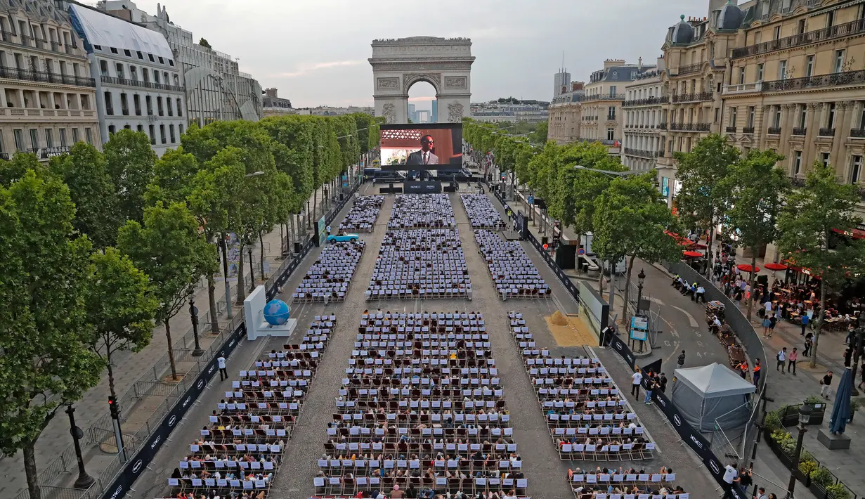 Suasana nonton film gratis di ruang terbuka di jalan Champs Elysees, Paris (7/7/2019). Pemutaran bioskop luar ruangan gratis di Paris musim panas ini menayangkan film Prancis dengan teks bahasa Inggris, untuk membantu Anglophones mengikuti budaya Prancis. (AP Photo/Michel Euler)