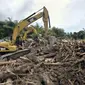 Eskavator memindahkan kayu yang terseret arus di Wasior, Papua Barat. Rehabilitasi pascabanjir Wasior kini difokuskan pada pembersihan serta pembuatan rumah hunian sementara (huntara).(Antara) 