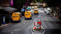 Bus berjalan di sepanjang jalan di Brisbane, Australia (30/6/2021). Kota itu menjadi sunyi karena dari penguncian dengan Australia memerangi wabah varian Delta yang sangat menular dari Covid-19. (AFP/Patrick Hamilton)