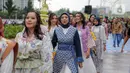 Sejumlah orang yang mengenakan batik berjalan di catwalk sepanjang Jalan Jenderal Sudirman, Jakarta, Minggu (2/10/2022). Kegiatan yang diikuti ratusan orang ini diselenggarakan oleh Bank Mandiri untuk menyambut Hari Batik Nasional yang jatuh setiap tanggal 2 Oktober 2022. (Liputan6.com/Faizal Fanani)