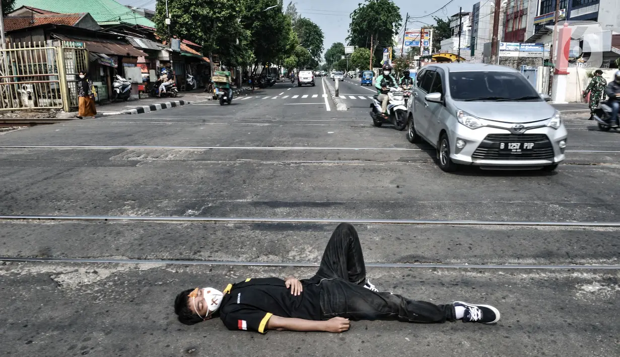 Aksi teatrikal sosialisasi keselamatan di perlintasan kereta api sebidang, Kemayoran, Jakarta, Rabu (14/10/2020). PT KAI Daop 1 menggelar sosialisasi dan aksi teatrikal dalam rangka meningkatkan kesadaran pengendara saat melintasi perlintasan sebidang. (merdeka.com/Iqbal Nugroho)