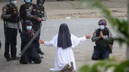 Suster Ann Rose Nu Tawng, biarawati Myanmar berlutut memohon kepada polisi untuk tidak menyakiti pengunjuk rasa di tengah tindakan keras terhadap demonstrasi menentang kudeta militer di Myitkyina di negara bagian Kachin Myanmar (8/3/2021). (Handout/Myitkyina News Journal/AFP)