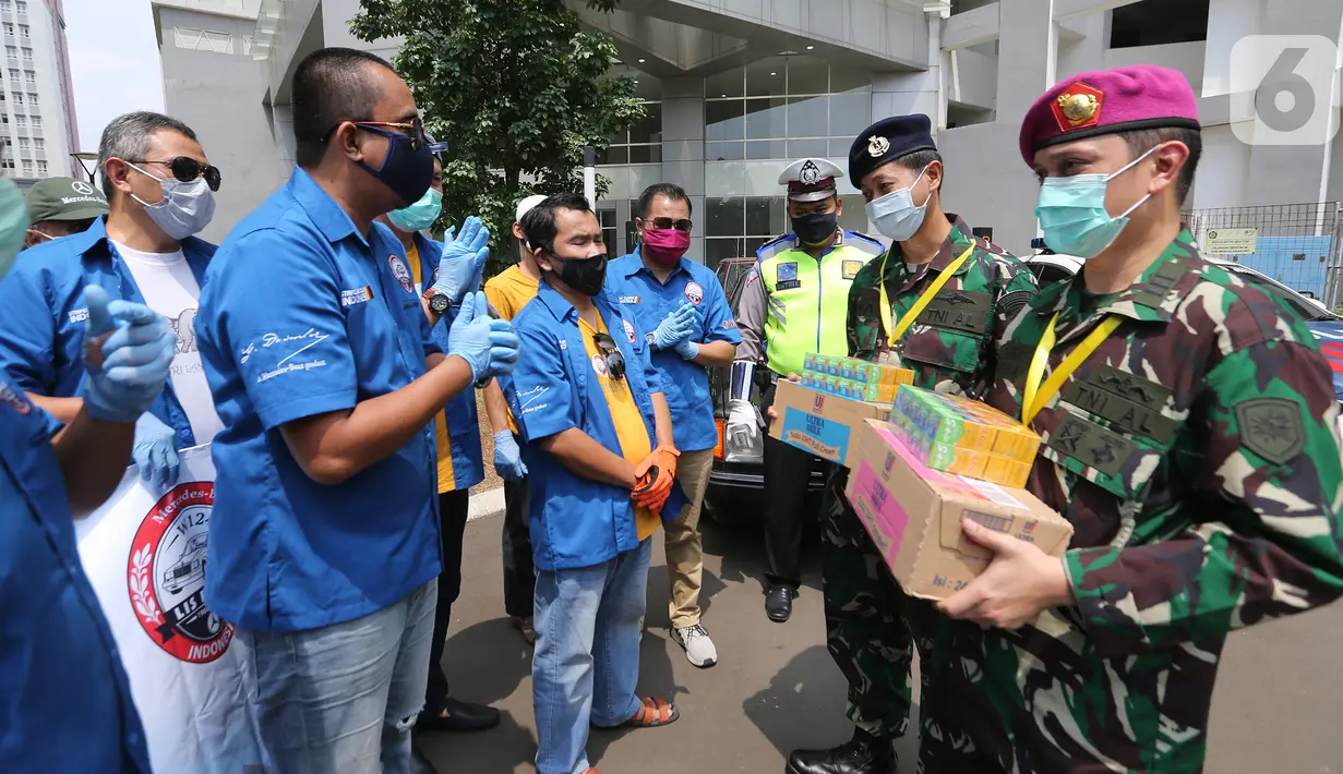 Perwakilan komunitas Mercy Boxer Lis Betjak Indonesia dan Wija Truss berbincang usai memberikan donasi kepada salah satu dokter di wisma Atlet Kemayoran, Jakarta, Sabtu (18/4/2020). Donasi berupa Vitamin C dan susu UHT untuk tenaga medis yang merawat pasien Covid-19. (Liputan6.com/Fery Pradolo)