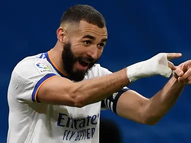 Ada yang menarik dari penampilan peraih Ballon d'Or 2022 Karim Benzema dalam tiga musim terakhir. Ia selalu terlihat mengenakan perban putih yang membalut telapak tangan kanannya saat bertanding di semua ajang kompetisi. Seakan telah menjadi ciri khas hingga kini, namun ternyata ada alasan tersendiri ia mengenakan aksesoris tersebut yang nyatanya jauh dari unsur gaya-gayaan yang akhirnya menjadi inspirasi Adidas merilis film pendek bertajuk Hand of Gold. (AFP/Pierre-Philippe Marcou)