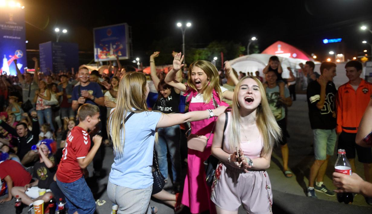 Suporter timnas Rusia bersorak merayakan kemenangan atas Mesir pada putaran kedua pertandingan grup A Piala Dunia di Rostov-on-Don, Rabu (20/6). Tuan rumah Piala Dunia, Rusia menang 3-1 dan kian berpeluang lolos ke 16 besar. (KHALED DESOUKI / AFP)