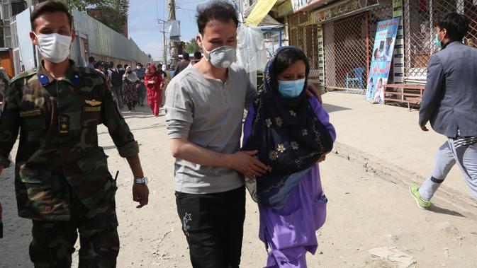Seorang pria Afghanistan membantu petugas kesehatan menyusul serangan di sebuah rumah sakit di Kabul, ibu kota Afghanistan (12/5/2020).  (Xinhua/Rahmatullah Alizadah)