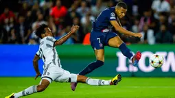 Pemain Juventus Juan Cuadrado (kiri) berebut bola dengan pemain Paris Saint-Germain (PSG) Kylian Mbappe pada pertandingan sepak bola Grup H Liga Champions di Stadion Parc des Princes, Paris, Prancis, 6 September 2022. PSG mengalahkan Juventus dengan skor 2-1. (AP Photo/Thibault Camus)