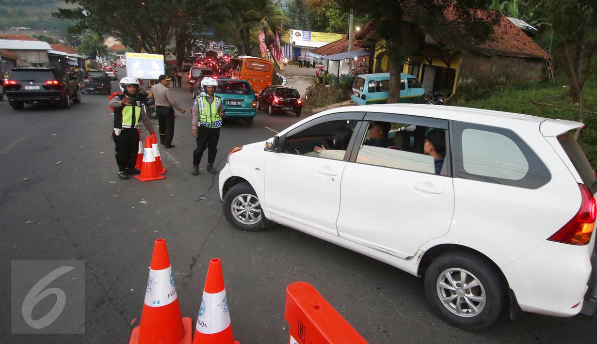 Petugas kepolisian mengatur arus lalu lintas di Simpang Nagreg, Jawa Barat, Sabtu (2/7). Polisi memberlakukan sistem rekayasa lalu lintas untuk menghindari kemacetan yang menuju ke Garut dan Tasik. (Liputan6.com/Immanuel Antonius)