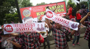 Massa pendukung Basuki Tjahaja Purnama (Ahok) asyik berjoget sambil membentangkan spanduk saat berlangsungnya sidang kasus dugaan penistaan agama di depan Gedung Kementerian Pertanian (Kementan), Jakarta, Selasa (31/1). (Liputan6.com/Immanuel Antonius)