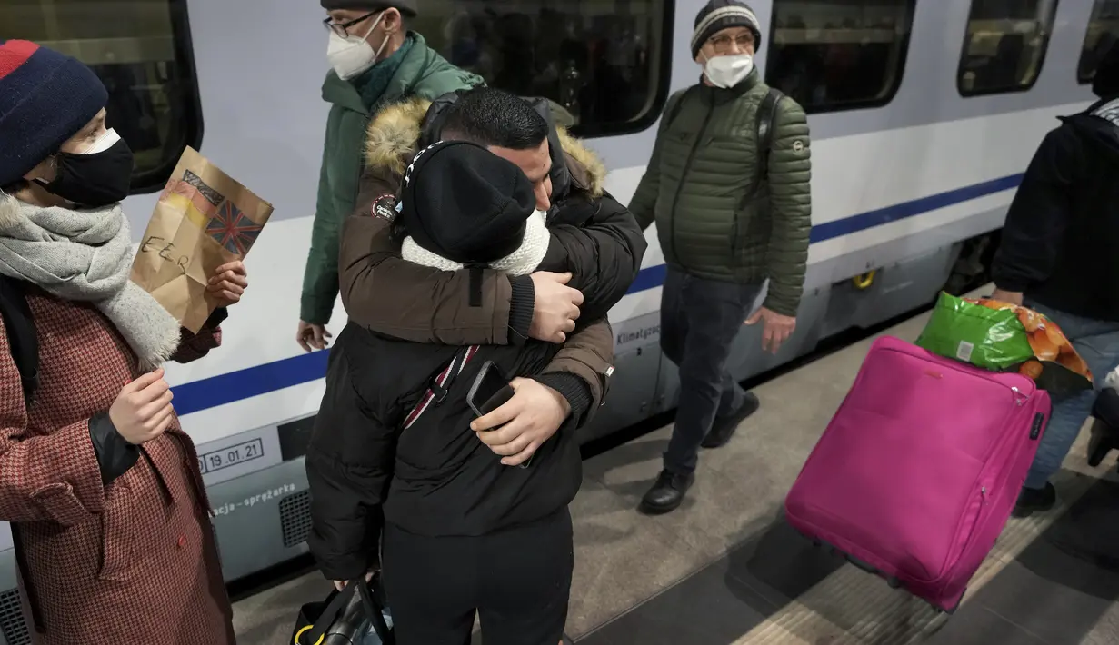 Orang-orang saling berpelukan setelah kedatangan kereta dengan pengungsi Ukraina di stasiun utama di Berlin, Jerman, Selasa (1/3/2022). Diperkirakan 300 orang tiba di Berlin dengan kereta api. Sejumlah relawan kemudian merawat orang-orang yang terdampar. (AP Photo/Michael Sohn)