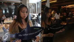 Aktivis Greenpeace Indonesia memperlihatkan replika hiu bertuliskan "Hiu Sehat untuk Laut Sehat" saat menggelar kampanye, Jakarta, Minggu (12/7/2015). Aksi tersebut sebagai upaya menyelamatkan hiu dari kepunahan. (Liputan6.com/Faizal Fanani)