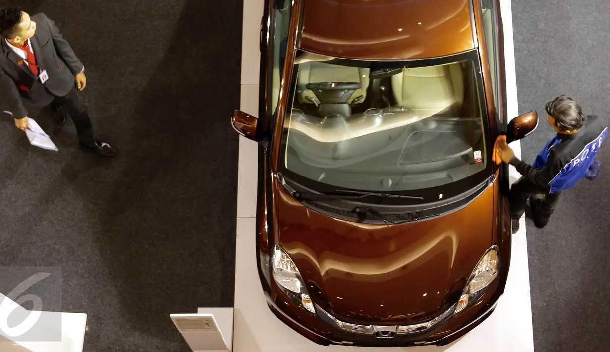 Seorang penjual berdiri di samping mobil saat pameran mobil Honda di Summarecon Mal Serpong, Tangerang, Minggu (29/11/2015). Pameran yang menghadirkan prototype Honda BRV banyak dimininati pengunjung. (Liputan6.com/Fery Pradolo)