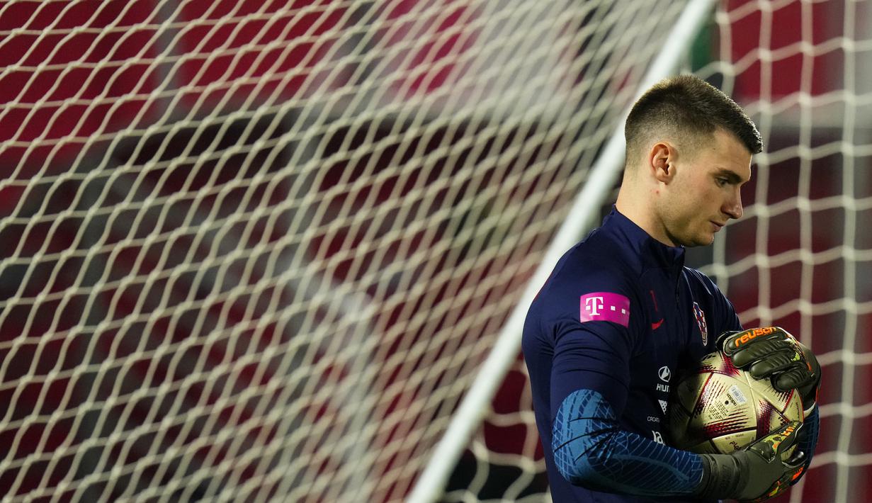 Kiper Kroasia Dominik Livakovic memegang bola saat sesi latihan timnas Kroasia pada Piala Dunia 2022 di Doha, Minggu (11/12/2022). Timnas Kroasia akan berduel melawan Argentina memperebutkan tiket final Piala Dunia 2022 di Stadion Lusail Iconic Qatar, Rabu (14/12/2022) mulai pukul 02.00 WIB. (AP Photo/Petr David Josek)