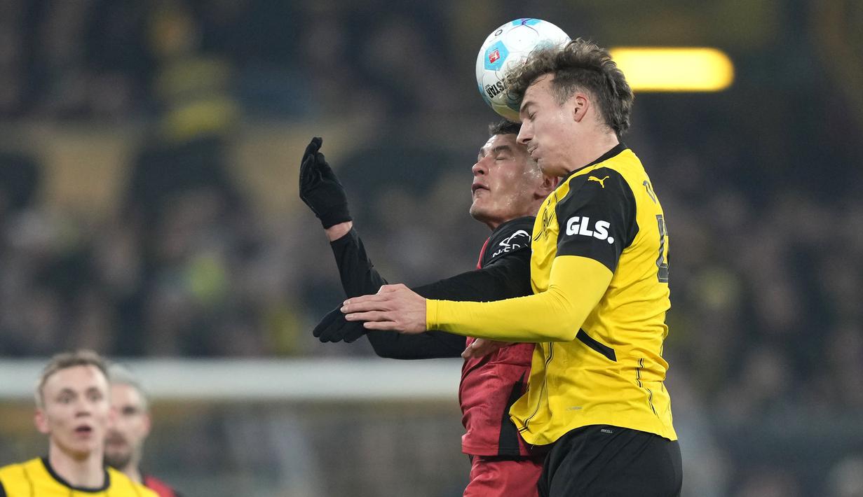 Pemain Borussia Dortmund, Yannik Luka (kanan) berduel dengan pemain Bayer Leverkusen Nathan Tella Karim Adeyemi pada laga lanjutan Bundesliga 2024/2025 di Signal Iduna Park, Dortmund, Jerman, Sabtu (11/01/2025) WIB. (AP Photo/Martin Meissner)