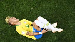 Striker Brasil, Neymar, menjerit kesakitan saat pertandingan melawan Swiss pada laga Piala Dunia di Stadion Rostov, Rusia, Senin (17/6/2018). Dilanggar sebanyak 10 kali membuat Neymar masuk rekor di Piala Dunia. (AFP/Jewel Samad)