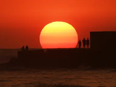 Sejumlah orang menyaksikan matahari terbenam di pantai El Tunco di La Libertad, 34 km sebelah selatan dari San Salvador, pada 5 Maret 2017. San Salvador adalah ibu kota sekaligus kota terbesar El Salvador.  (AFP Photo / Marvin Recinos)
