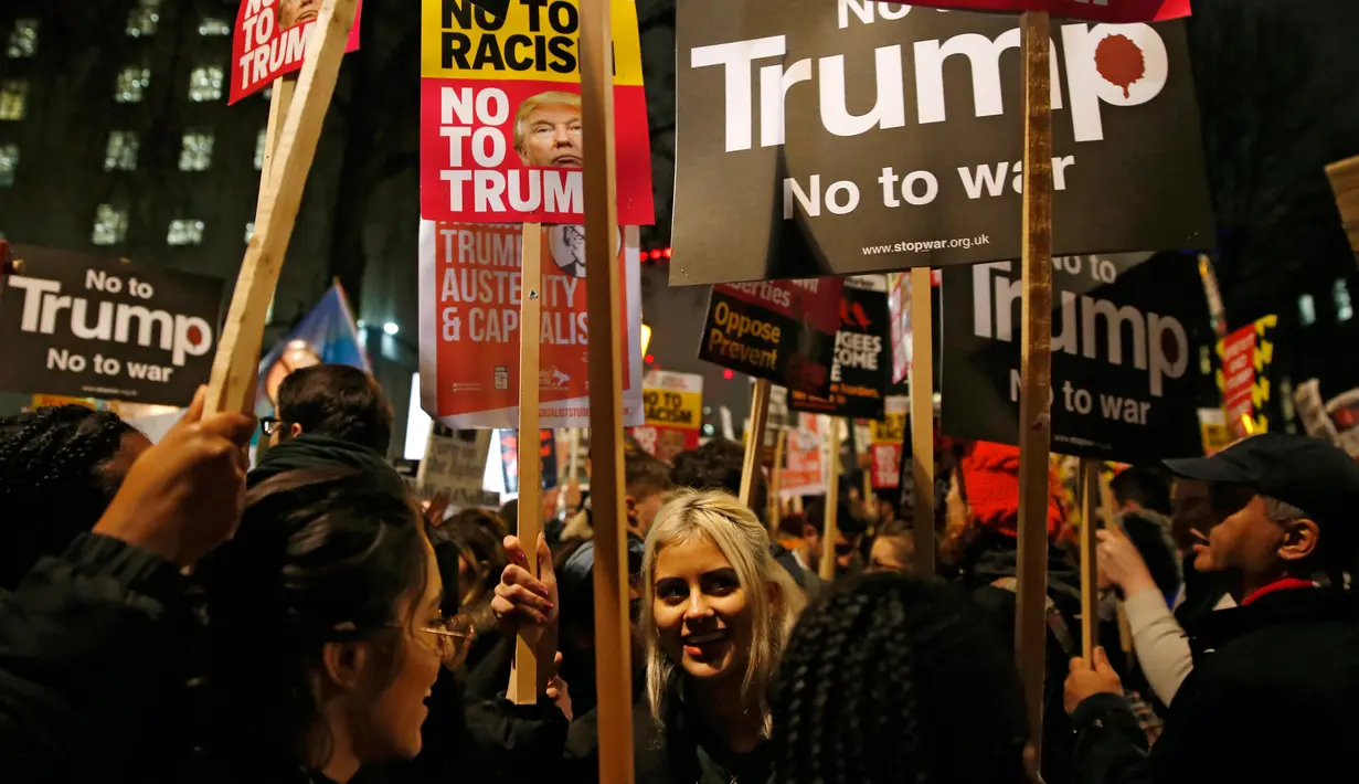 Seorang wanita ikut ambil bagian dalam unjuk rasa di luar Downing Street, London, Senin (30/1). Aksi tersebut memprotes kebijakan Presiden AS Donald Trump yang melarang Muslim dari sejumlah negara memasuki Amerika Serikat. (AP Photo/Alastair Grant)