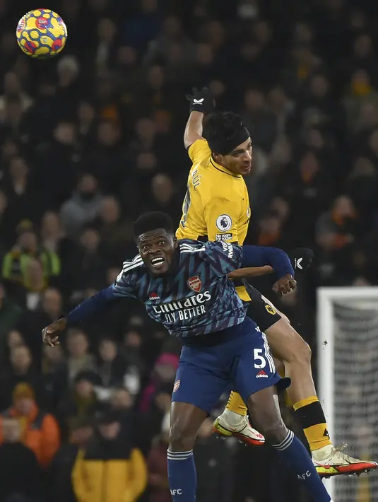 Gelandang Arsenal, Thomas Partey berebut bola dengan penyerang Wolverhampton Wanderers, Raul Jimenez selama pertandingan lanjutan Liga Inggris di stadion Molineux di Wolverhampton, Inggris, Jumat (11/2/2022). Arsenal menang tipis atas Wolverhampton Wande 1-0. (AP Photo/Rui Vieira)