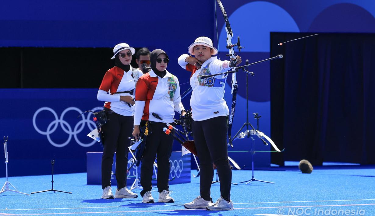 <p>Atlet panahan putri Indonesia, Rezza Octavia (depan) melepaskan anak panah pada laga perempatfinal panahan beregu putri Olimpiade Paris 2024 menghadapi China di Invalides Arena, Paris, Minggu (28/7/2024). Indonesia kalah 1-5 dari China. (Dok. NOC Indonesia/Naif Muhammad Al'as)</p>