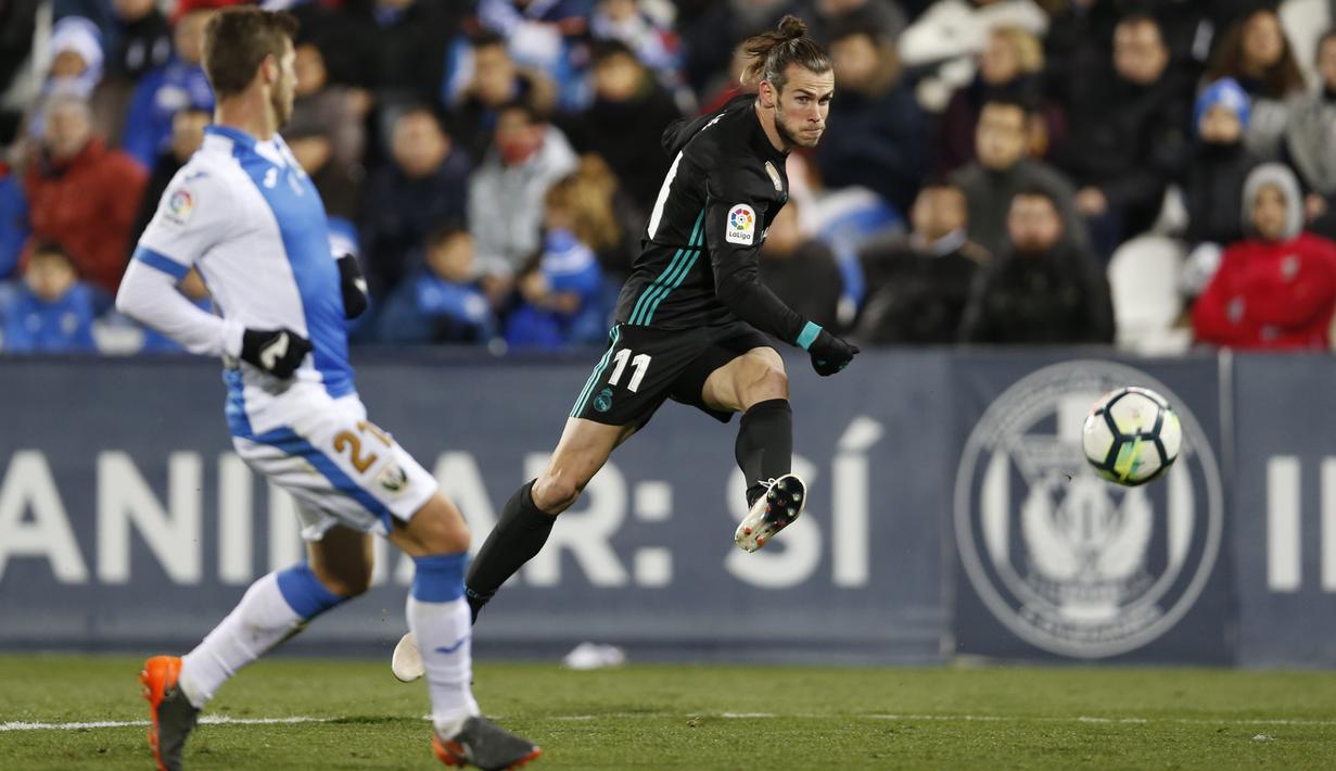 Pemain Real Madrid, Gareth Bale (kanan) melepaskan tembakan melewati adangan pemain Leganes, Ruben Perez pada lanjutan La Liga Santander di Butarque stadium, Leganes, (21/2/2018). Real Madrid menang 3-1.  (AP/Francisco Seco)