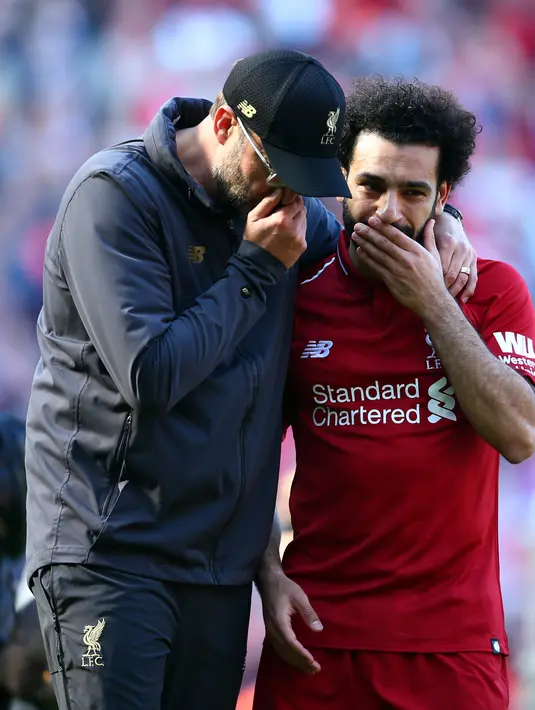 Manajer Liverpool Juergen Klopp (kiri) berbicara dengan Mohamed Salah yang menangis usai laga Liga Inggris menghadapi Wolverhampton Wanderers di di Stadion Anfield, Liverpool, Inggris, Minggu (12/5/2019). Liverpool gagal meraih gelar juara Liga Inggris. (AP Photo/Dave Thompson)