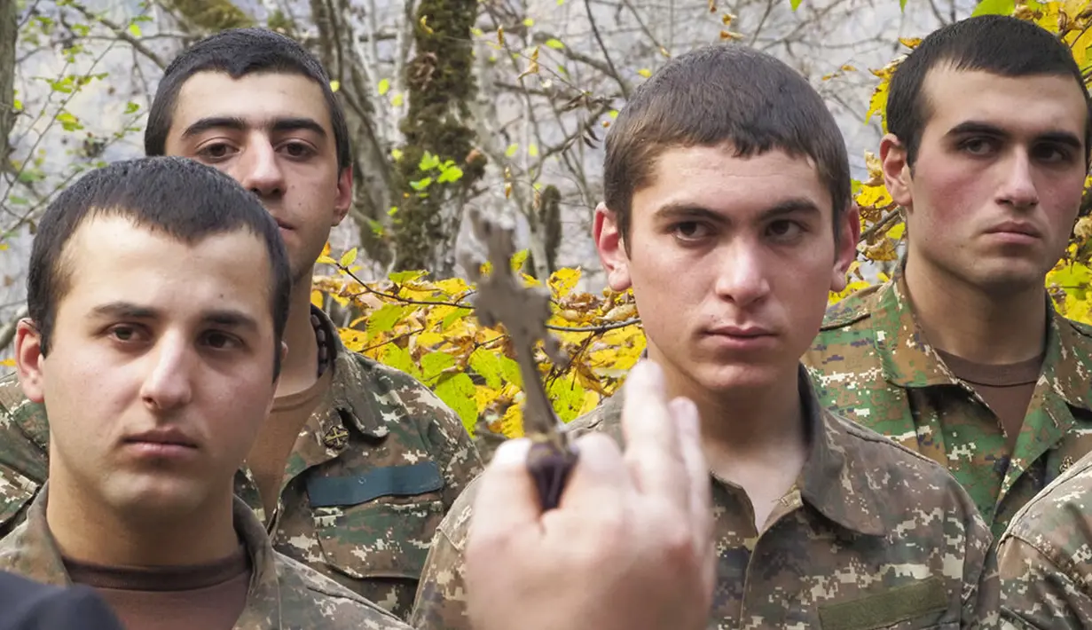 Seorang pendeta membaptis tentara etnis Armenia di sebuah kamp militer dekat garis depan konflik di wilayah separatis Nagorno-Karabakh, Azerbaijan, Senin (2/11/2020). Pasukan Armenia dan Azerbaijan saling menyalahkan atas serangan baru selama perebutan Nagorno-Karabakh. (AP Photo)