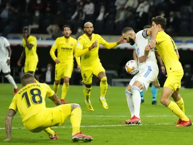 Penyerang Real Madrid Karim Benzema berebut bola dengan bek Villarreal pada jornada ketujuh La Liga Spanyol di Santiago Bernabeu, Minggu (26/9/2021) dini hari WIB. Real Madrid hanya mampu bermain imbang tanpa gol kala menjamu Villarreal. (AP Photo/Manu Fernandez)