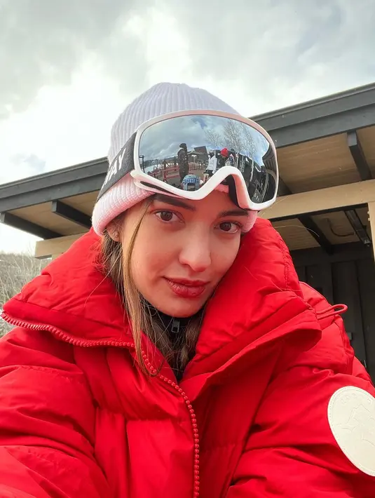 Liburan di Aspen, Colorado, penampilan kece Nia Ramadhani dengan puffer jacket merah, beanie, dan kacamata ski-nya. [@ramadhniabakrie]