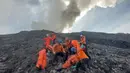Foto selebaran yang diambil pada 4 Desember 2023 dan dirilis pada 5 Desember 2023 oleh Badan SAR Nasional (BASARNAS) ini menunjukkan para petugas penyelamat mengevakuasi salah satu korban dari lereng Gunung Marapi di Sumatra Barat. (Handout / BASARNAS / AFP)
