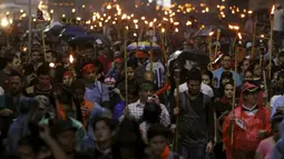 Ribuan orang membawa obor turun ke jalan menuntut Presiden Honduras, Juan Hernandez untuk  mundur di Tegucigalpa, Jumat (24/7/2015).  Massa menuntut Presiden Juan Hernandez turun atas dugaan korupsi. (REUTERS/Jorge Cabrera)