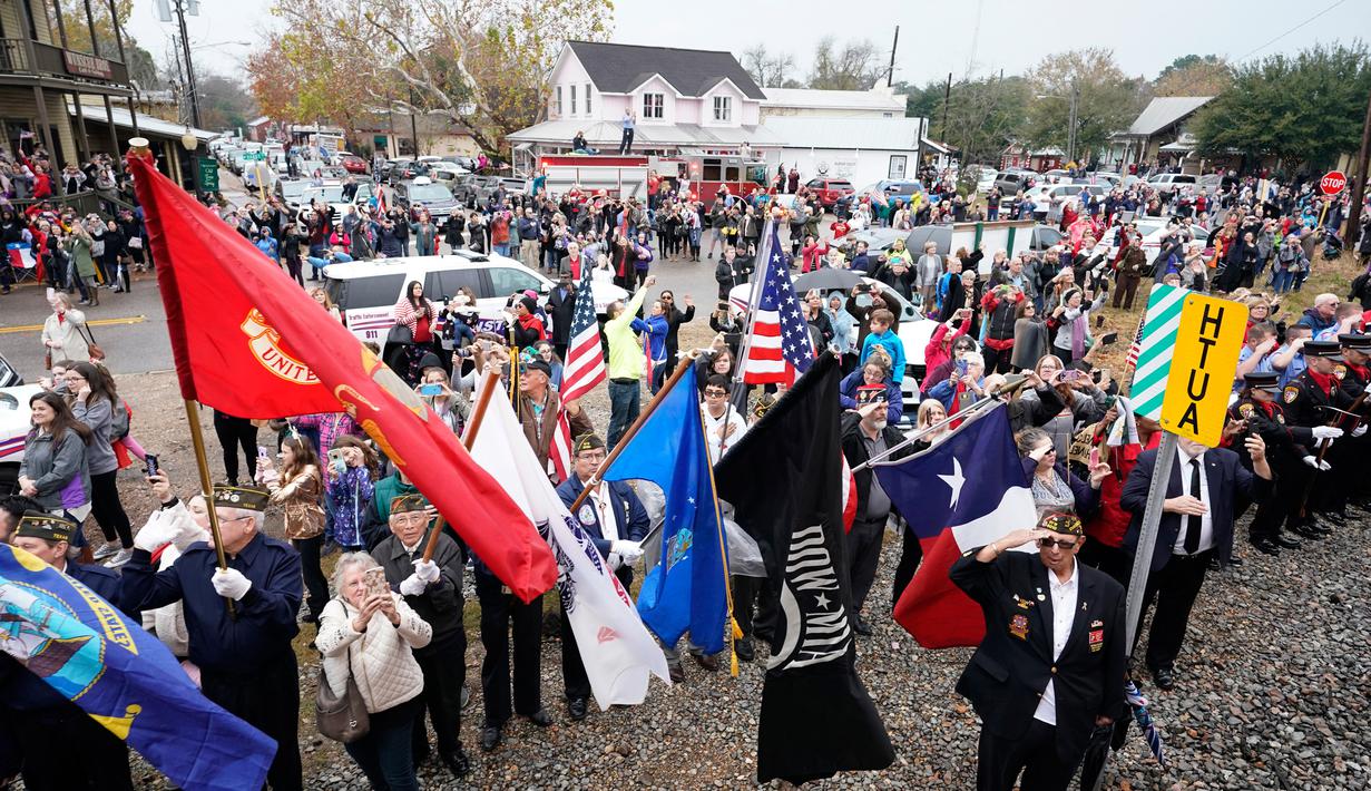 Warga memberi penghormatan terakhir saat kereta pembawa jenazah Presiden ke-41 AS George HW Bush melintas dari Spring ke College Station, Texas, Kamis (6/12). (AP Photo/David J. Phillip, Pool)