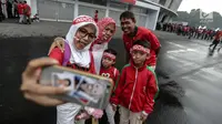 Satu keluarga suporter Timnas Indonesia berpose di depan Stadion Gelora Bung Karno (GBK), Senayan, Jakarta, Minggu (14/1). Menghadapi Islandia, Timnas Indonesia akan didominasi oleh pemain U-23. (Liputan6/Faizal Fanani)