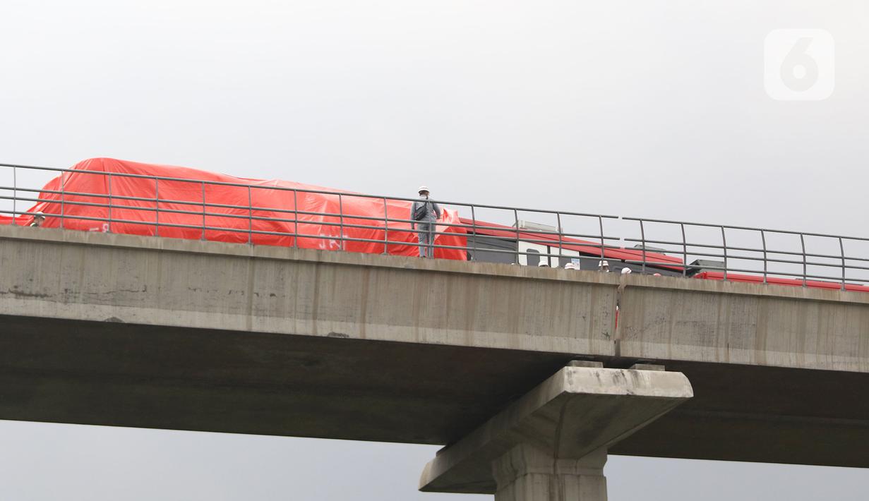 Petugas mengecek kereta ringan lintas rel terpadu (LRT) Jabodebek yang mengalami kecelakaan di jalur lintas LRT Cibubur, Jakarta Timur, Senin (25/10/2021). Dua kereta LRT tersebut sedang uji coba saat tabrakan terjadi sehingga gerbong kosong. (Liputan6.com/Herman Zakharia)