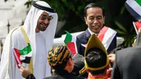 Presiden Jokowi bersama Putra Mahkota Abu Dhabi, Sheikh Mohamed Bin Zayed Al Nahyan menyapa sejumlah anak berpakaian daerah saat kunjungan kenegaraan di Istana Bogor, Kamis (24/7/2019). Keduanya menggelar pertemuan bilateral guna membahas sejumlah kerja sama. (Willy Kurniawan/Pool Photo via AP)