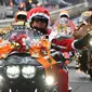 Sejumlah pengendara motor gede mengenakan kostum Santa Claus dan rusa di kota Tokyo, Jepang, (23/12). Touring ini dinamakan "Toy Run" yang diselenggarakan oleh komunitas Harley Santa Club. (AFP PHOTO/Toru Yamanaka)