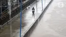 Pengendara melintas di jalan inspeksi Banjir Kanal Barat di Kawasan Tanah Abang, Jakarta, Rabu (1/1/2020). Hujan yang mengguyur Jakarta sejak Selasa sore (31/12/2019) mengakibatkan debit air Banjir Kanal Barat tinggi dan hampir meluap. (Liputan6.com/Helmi Fithriansyah)