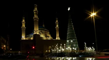 Sebuah pohon Natal raksasa yang dirancang oleh desainer Lebanon, Elie Saab terlihat berdiri di depan Masjid Al-Amin, di pusat kota Beirut, 12 Desember 2015. (REUTERS/Jamal Saidi)