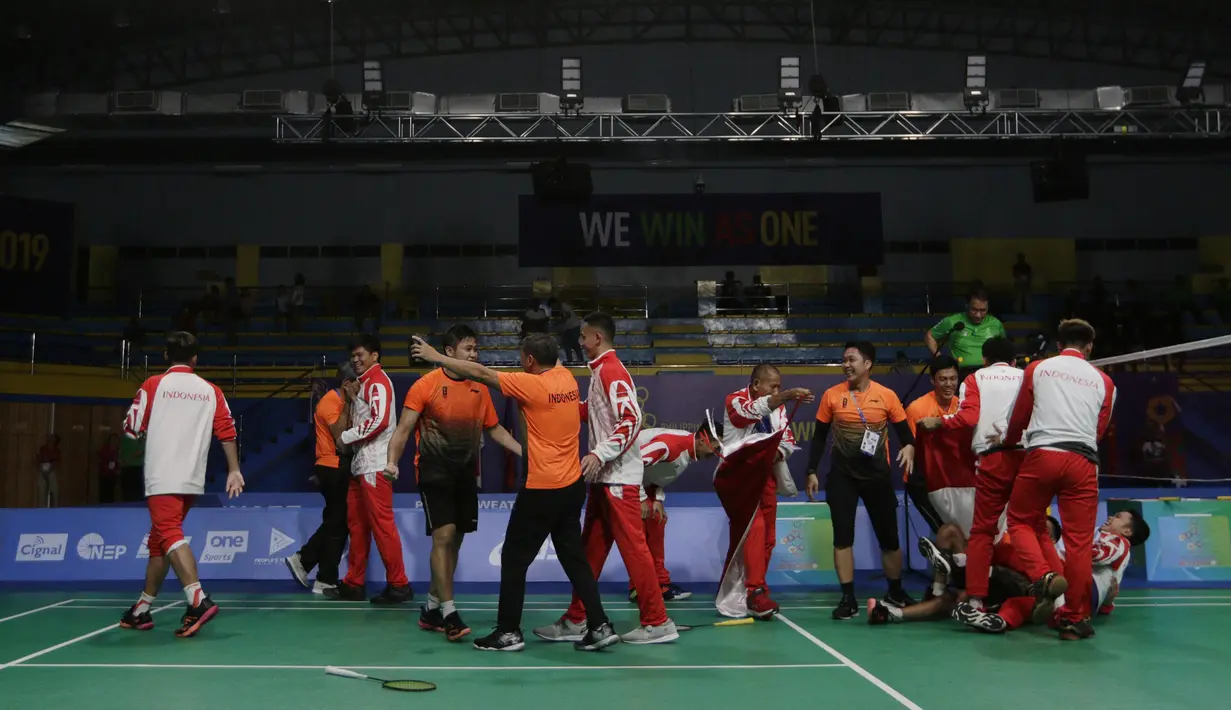 Pemain dan pelatih tim beregu putra Indonesia merayakan gelar juara cabang bulutangkis SEA Games 2019 di Multinlupa Sport Center, Rabu (4/12). Indonesia meraih emas setelah menang 3-1 atas Malaysia. (Bola.com/M Iqbal Ichsan)