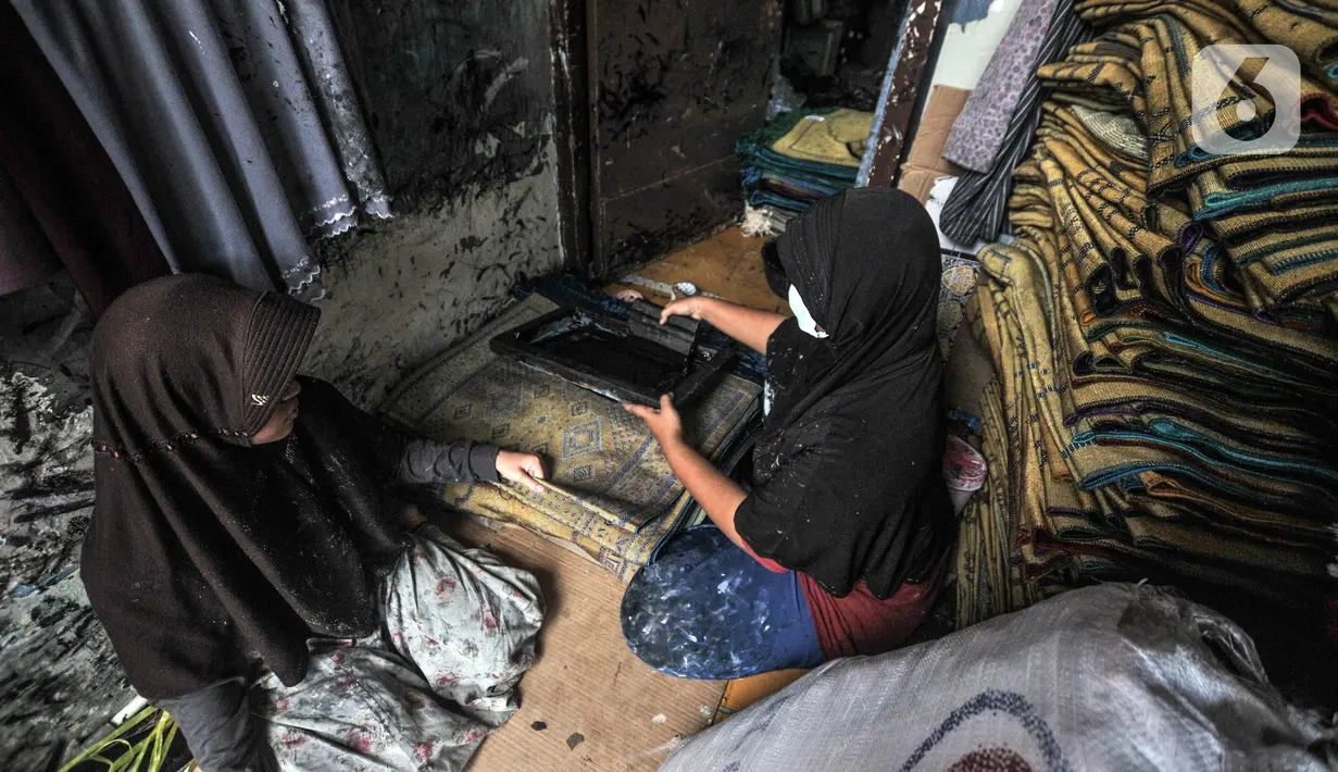 Fitri (40) menyelesaikan jasa sablon sajadah di Amang Sablon, Kebon Melati, Jakarta Pusat, Kamis (7/4/2022). Industri rumahan tersebut mengalami peningkatan sebesar 50 persen di bulan Ramadhan 1443 H jika dibandingkan bulan biasanya. (merdeka.com/Iqbal S. Nugroho)