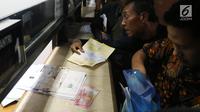 Warga membayar pajak kendaraan di Samsat Polda Metro Jaya, Jakarta, Jumat (16/11). Pemprov DKI menghapuskan sanksi administrasi Pajak Kendaraan Bermotor (PKB) dan sanksi administrasi Bea Balik Nama Kendaraan Bermotor (BBN-KB). (Liputan6.com/Johan Tallo)