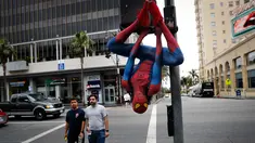 Rashad Rouse mengenakan kostum Spider-Man sembari bergelantungan di tiang lalu lintas untuk menarik perhatian turis di Hollywood Boulevard, Los Angeles, 25 Mei 2017. Pria 27 tahun itu bermimpi namanya akan masuk di Hollywood Walk of Fame (AP/Jae C. Hong)
