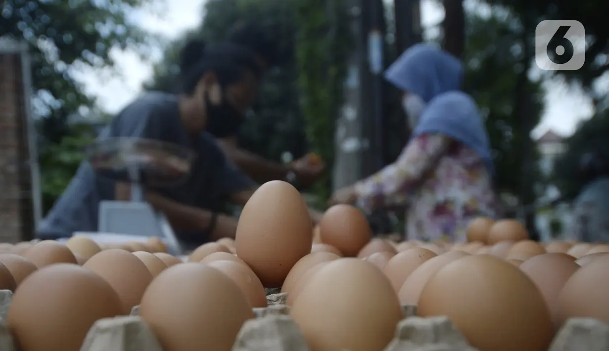 Pedagang telur melayani pembeli di pinggir jalan kasawan Perumahan Nusa Indah, Tangerang Selatan, Banten, Jumat (22/5/2020). Jelang Lebaran, harga telur eceran terpantau masih normal. (merdeka.com/Dwi Narwoko)