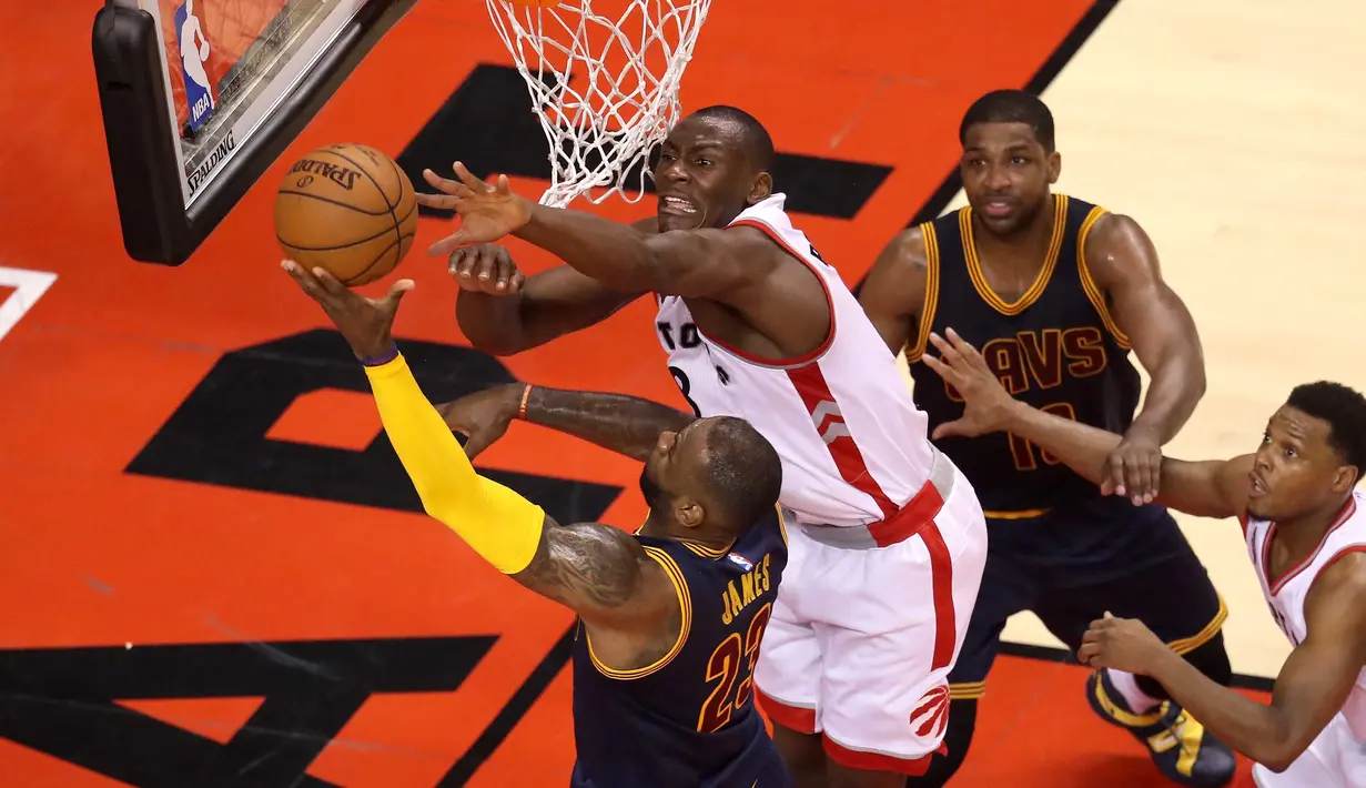 Pemain Raptors, Bismack Biyombo #8 menghadang pemain Cavaliers, LeBron James #23 pada final Wilayah Timur NBA Playoffs 2016 di Air Canada Centrer, Selasa (24/5/2016), Toronto, Ontario, Canada. Raptor menang 105-99. (Tom Szczerbowski/Getty Images/AFP)