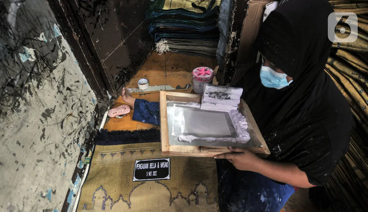 Fitri (40) menyelesaikan jasa sablon sajadah di Amang Sablon, Kebon Melati, Jakarta Pusat, Kamis (7/4/2022). Amang Sablon kini mampu menyelesaikan produksi sablon sajadah sebanyak 17-20 kodi per hari. (merdeka.com/Iqbal S. Nugroho)