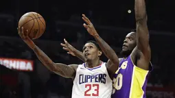 Aksi pemain Clippers, Lou Williams (kiri) melakukan lay up melewati adangan pemain Lakers, Julius Randle pada laga NBA basketball games di Staples Center, Los Angeles, California, (27/11/2017). Clippers menang atas Lakers 120-115. (AP/Jae C. Hong)