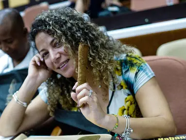 Peserta wanita menunjukkan cerutu yang dibuatnya selama kelas master dalam Festival Havana Cigar ke-20 di Istana Konvensi di Havana, Kuba (28/2). (AFP Photo/Adalberto Roque)