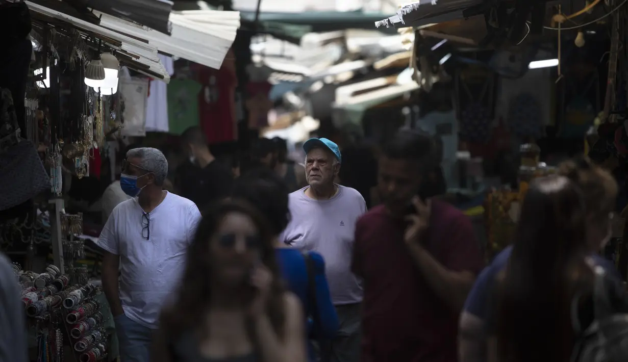 Orang Israel berjalan di pasar di Tel Aviv, Minggu (18/4/2021). Israel mencabut aturan wajib masker di ruang publik luar ruangan dan membuka kembali sekolah sepenuhnya dalam upaya menuju normalisasi setelah kampanye vaksinasi Covid-19 berjalan sukses. (AP Photo/Sebastian Scheiner)