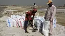 Buruh menyiapkan kantong garam laut setelah mengumpulkan dari daerah pesisir dekat Karachi, Pakistan, Sabtu (13/11/2021). Buruh memperoleh rata-rata 1.050 rupee Pakistan (US$ 6) per hari dari pekerjaan mereka untuk mencari nafkah bagi keluarga. (AP Photo/Fareed Khan)