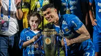 Selebrasi striker Persib Bandung, Ciro Alves dengan trofi juara bersama sang putri, Bella dalam perayaan gelar juara Championship Series BRI Liga 1 2023/2024 setelah mengalahkan Madura United 3-1 pada laga final leg kedua di Stadion Gelora Bangkalan, Madura, Jumat (31/5/2024). (Bola.com/Bagaskara Lazuardi)